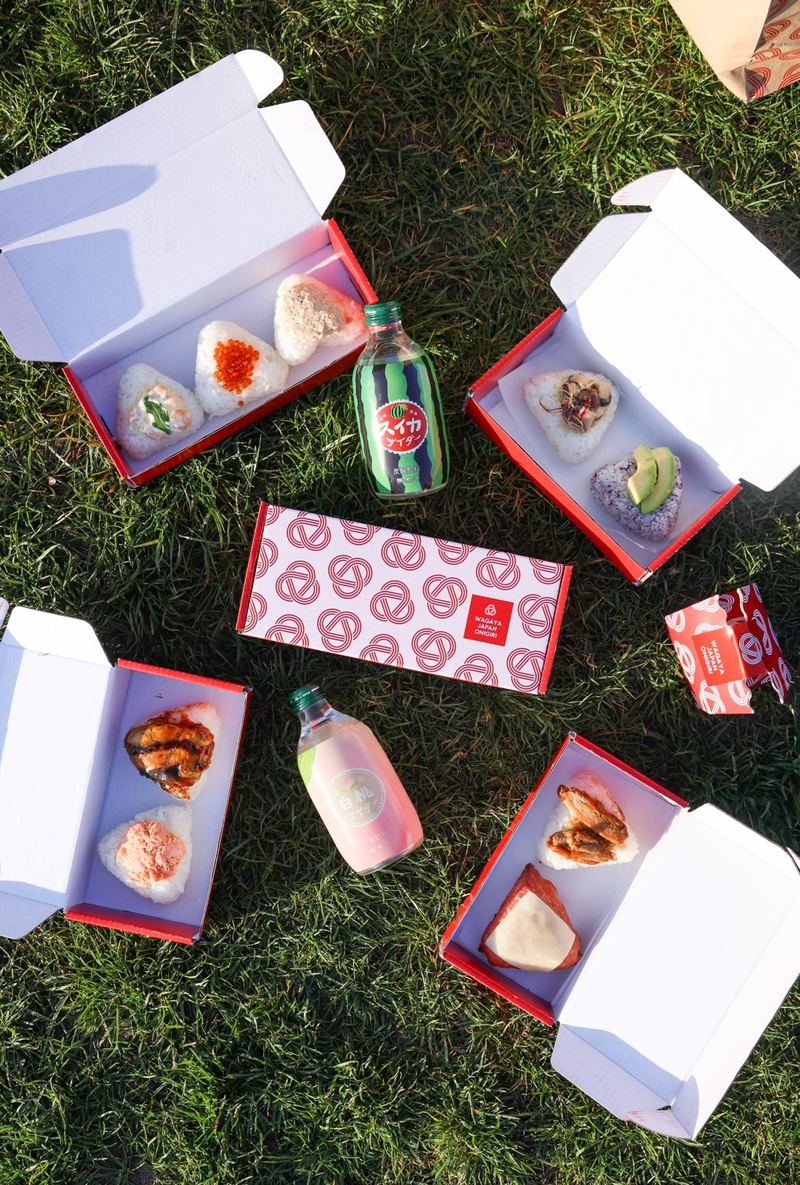 Wagaya red lunch boxes with onigiri on the grass